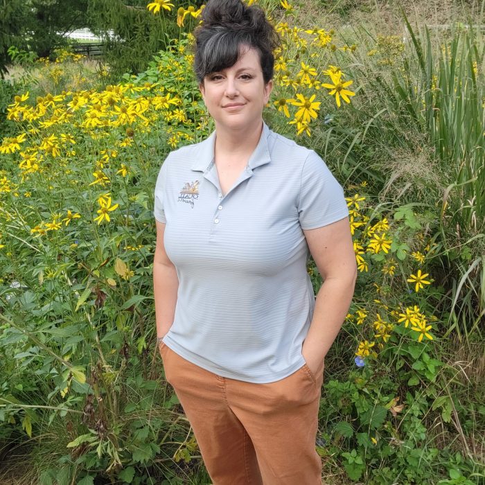 woman standing next to native plants